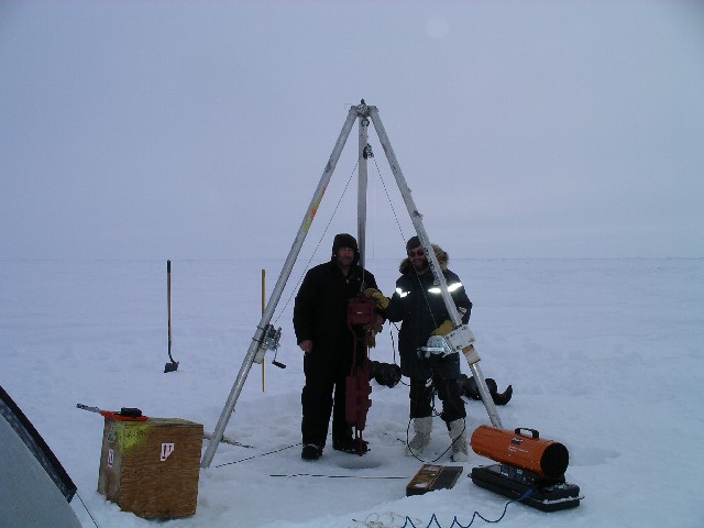 [Dean and Tim lowering the instrument package through the ice hole]